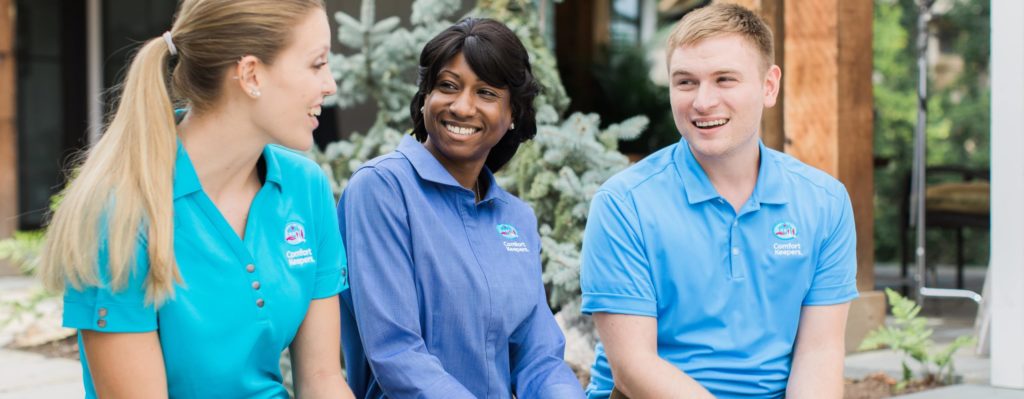 Three well-trained caregivers sits next to each other, having fun and enjoying their fulfilling job.