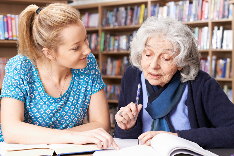 Senior with Caregiver in Library | Sundown Syndrome | BLOG POST | Comfort Keepers Vancouver